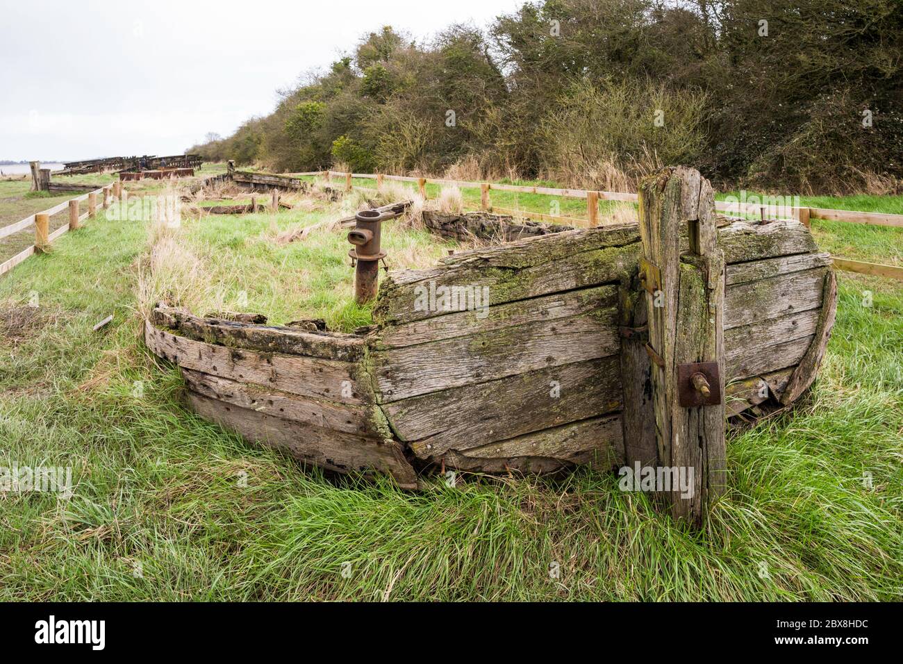 La chiatta Kennet Harriett è tra le barche che si abbarbaccano accanto al Severn per rinforzare le rive del fiume. Purton Hulks, Gloucestershire, Inghilterra, Regno Unito. Foto Stock