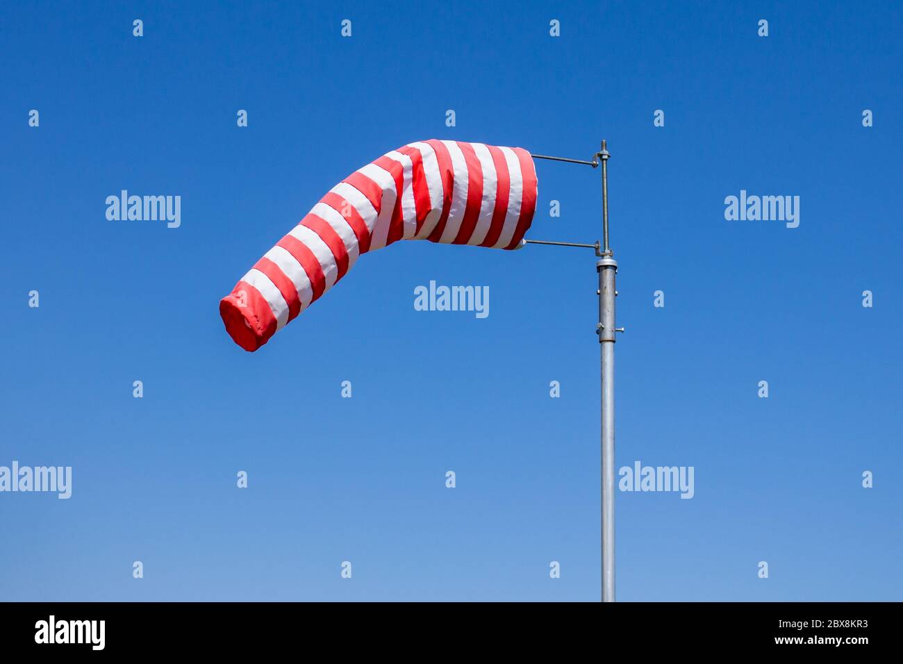 Flag Windsock, misuratore della velocità del vento, strisce rosse e bianche su sfondo blu Foto Stock