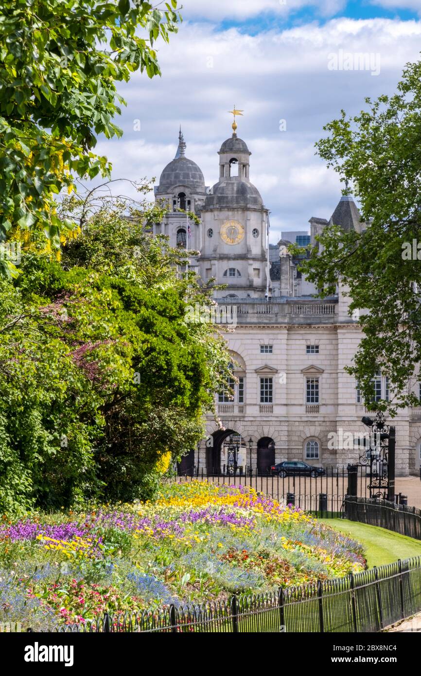 Regno Unito, Inghilterra, Londra. Edificio delle Guardie a cavallo del Parco di San Giacomo che mostra fiori di primavera nei letti fioriti Foto Stock