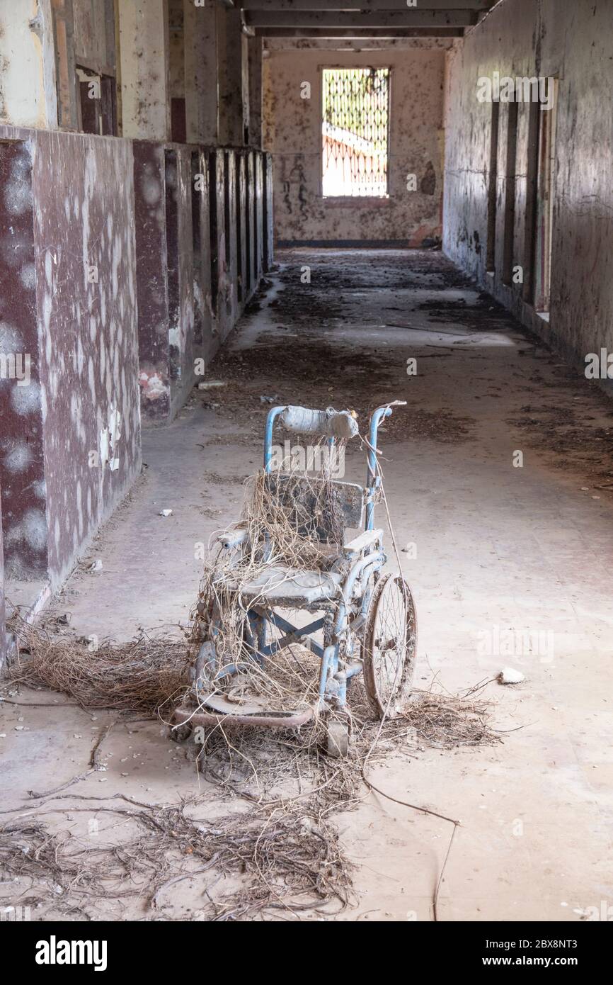 Sedia a rotelle nel corridoio di un ospedale o di una scuola abbandonati Foto Stock