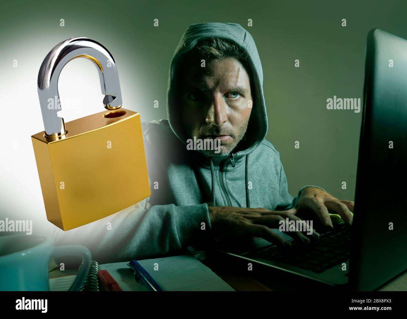 aperto lucchetto composito con giovane pericoloso e abile hacker manprogramming su computer laptop sistema di cracking password in protezione della privacy e. Foto Stock