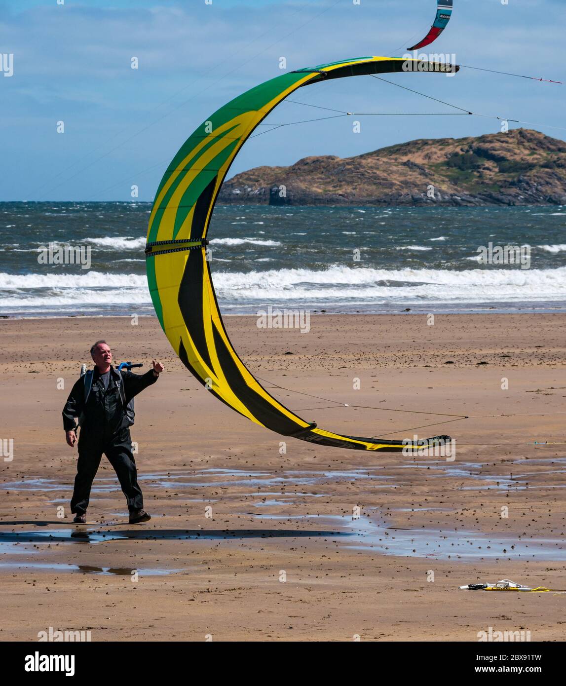Firth of Forth, Scozia, Regno Unito, 6 giugno 2020. UK Weather: Un kite surfer ritorna al mare dopo il blocco di alleggerimento permette alcuni sport all'aperto. Dopo un inizio noioso in una giornata tempesta il sole è uscito per creare le giuste condizioni a Broadsands Bay Foto Stock