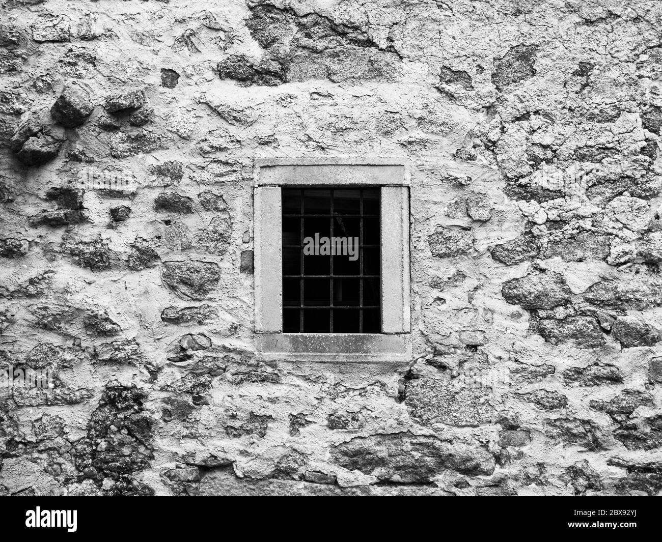 Vecchia prigione con finestra di prigione con barre di metallo arrugginito. Immagine di stile vintage. Immagine in bianco e nero. Foto Stock