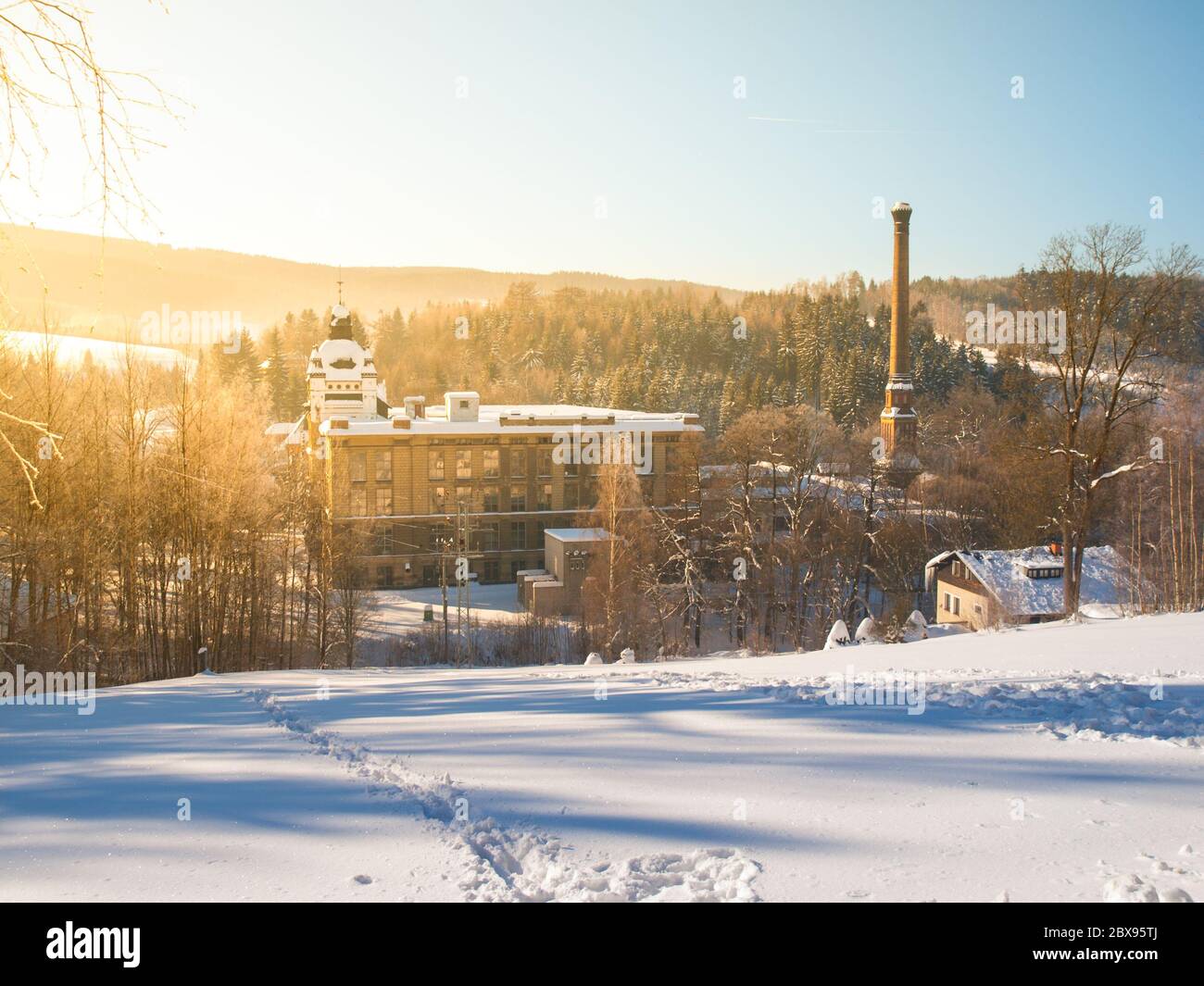 Vecchia fabbrica tessile chiamato Klaster, Monastero, con camino in inverno, Tanvald, Boemia settentrionale, Repubblica Ceca, Europa. Foto Stock