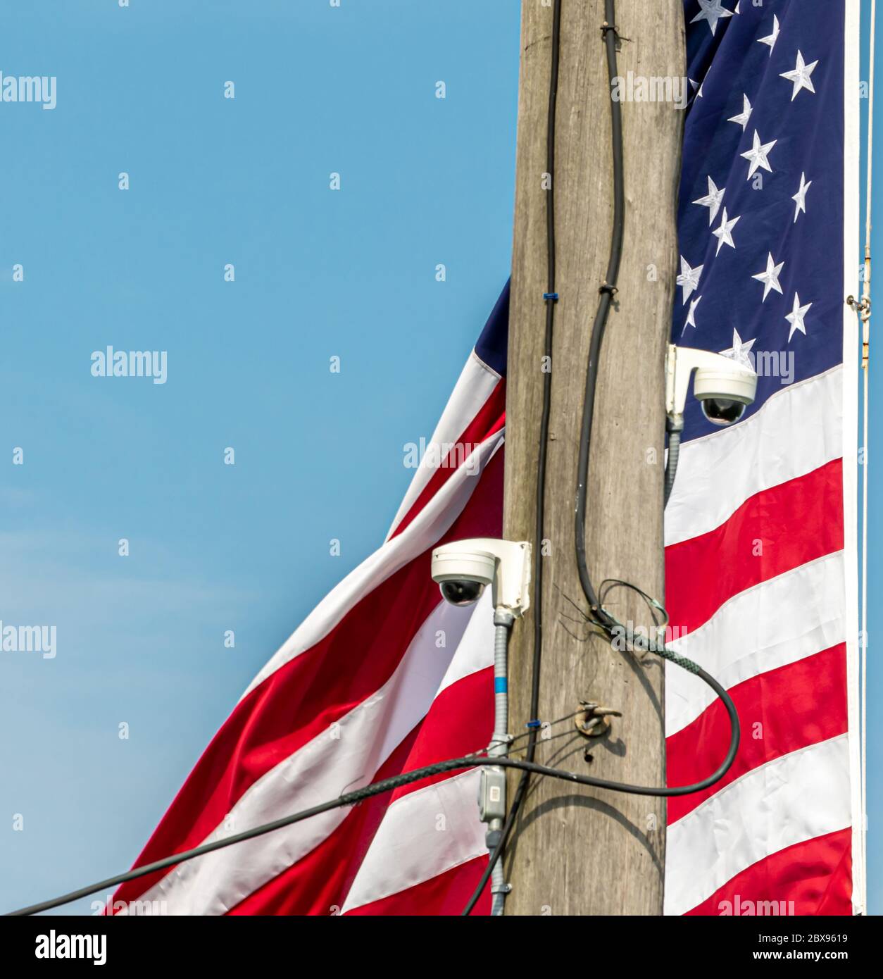 Bandiera americana con telecamere montate su un palo vicino Foto Stock