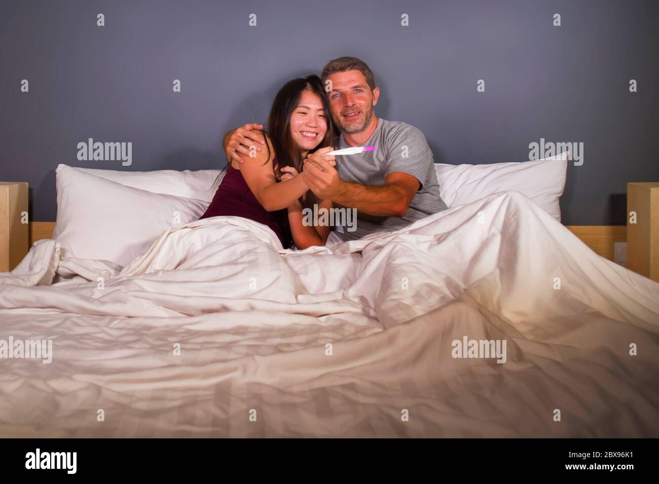 giovane bella e felice coppia insieme a letto guardando il