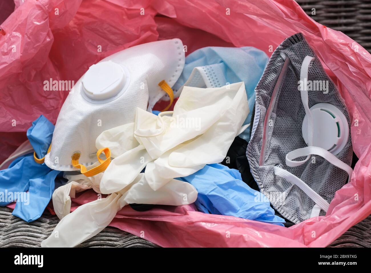Maschera medica e guanti di rifiuti sporchi in bidone rifiuti, coronavirus malattia attrezzature Foto Stock
