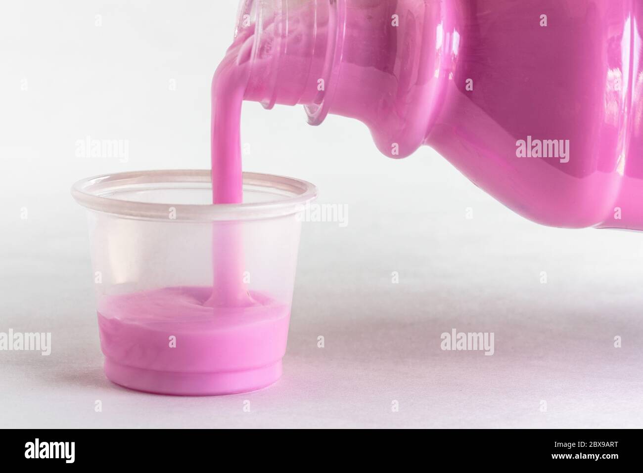 Versando una dose di antiacido Foto Stock