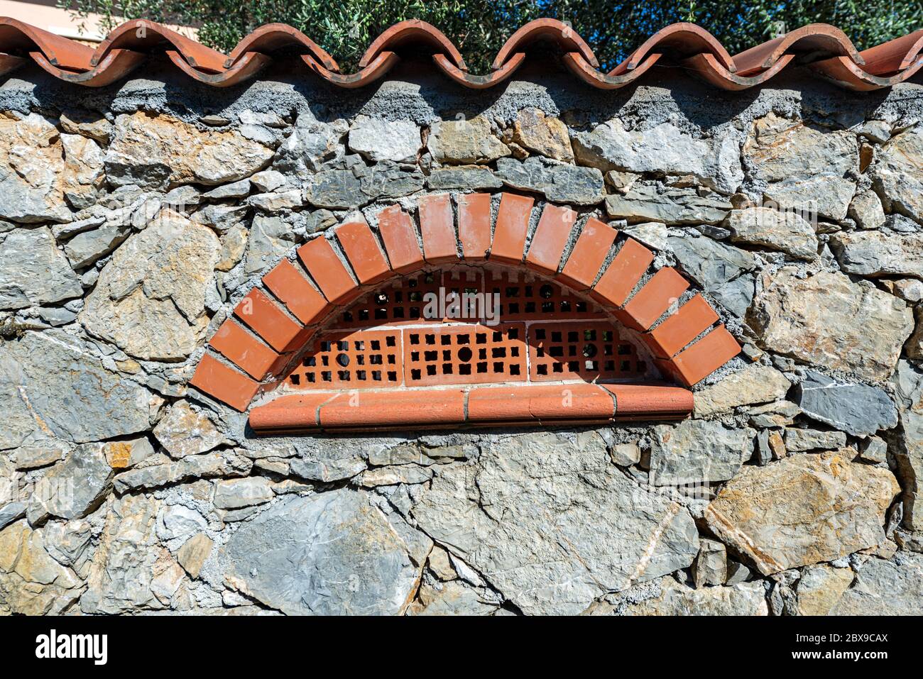 Antico muro di confine con finestra in mattoni e tetto con pianelle in  terracotta (argilla). Liguria, Italia, Europa Foto stock - Alamy
