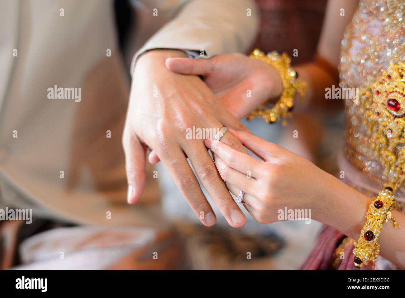 Sposa e Ginestra che mette l'anello di nozze sul dito, cerimonia di fidanzamento di nozze thailandese Foto Stock