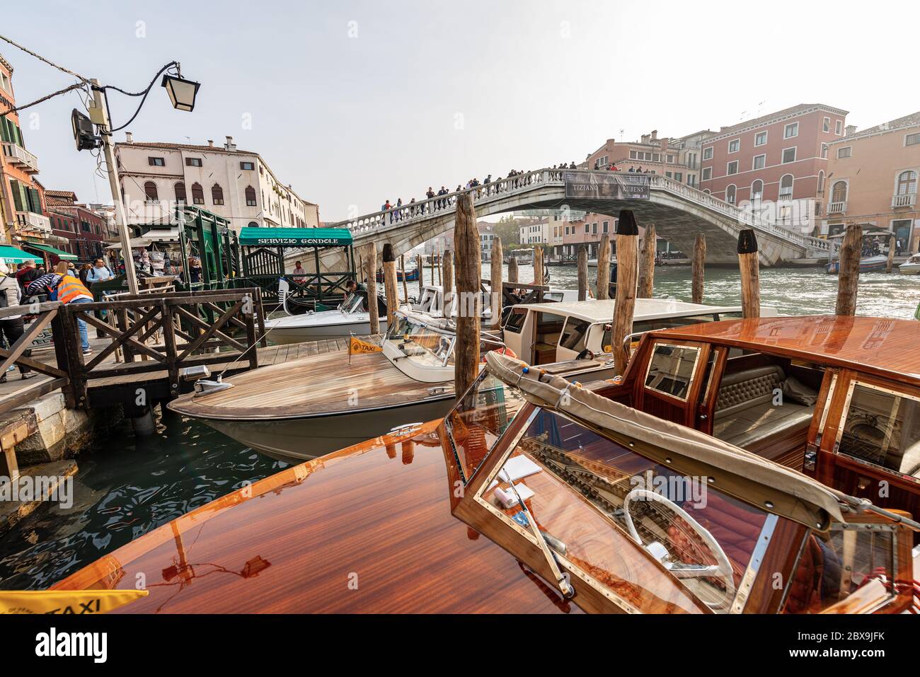 Taxi e gondole ormeggiate di fronte alla stazione ferroviaria di Venezia nel Canal Grande. Molti turisti attraversano il ponte Scalzi. Italia, Veneto, Europa Foto Stock