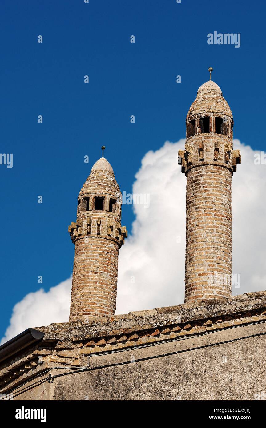 Primo piano di due antichi camini e tetto su un cielo blu con nuvole. Provincia di Verona, Veneto, Italia, Europa Foto Stock