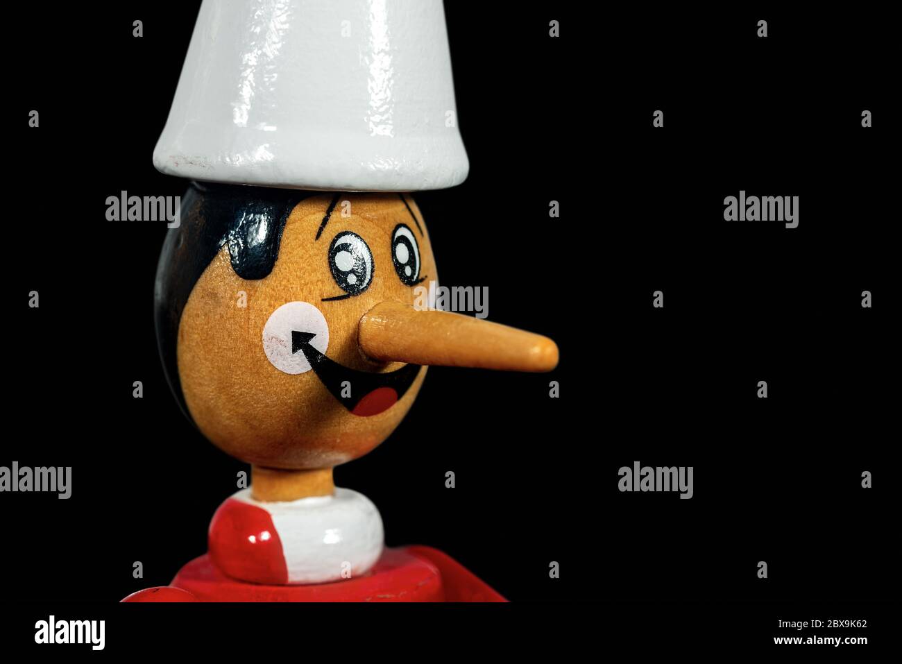 Primo piano di un giocattolo in legno Pinocchio isolato su sfondo nero con spazio per la copia. Personaggio della fiaba scritto da Carlo Collodi Foto Stock