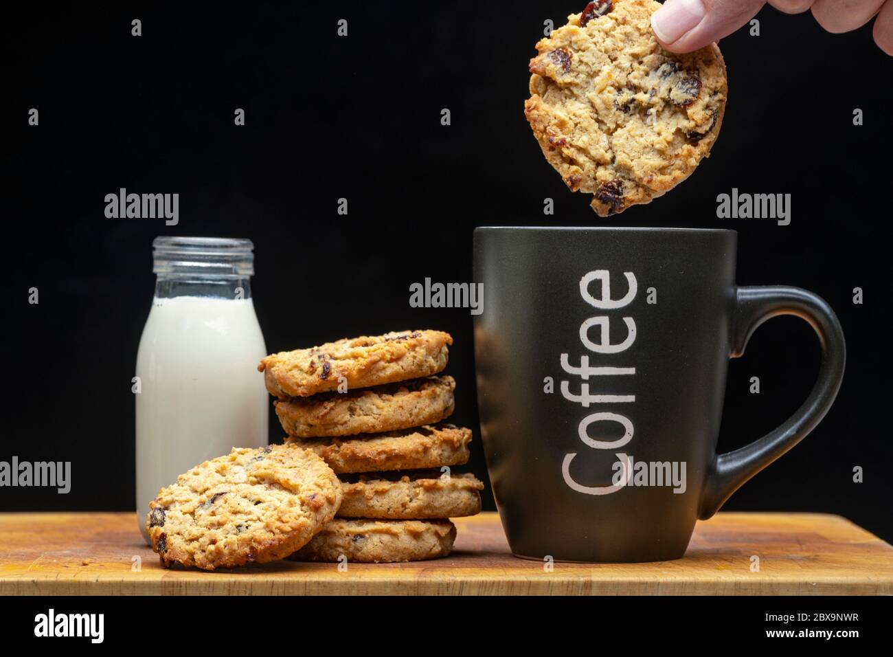 Inzuppando un biscotto in una tazza di caffè Foto Stock