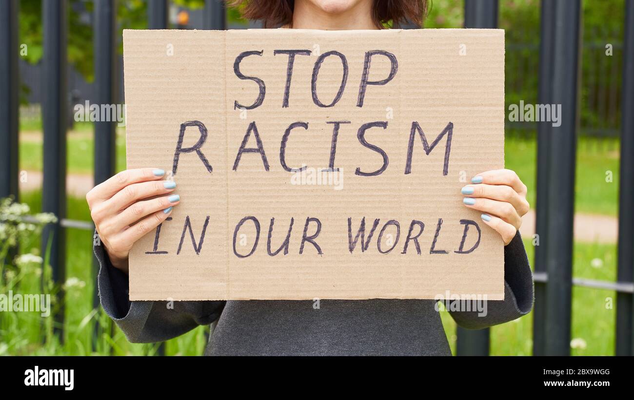 Fermare il concetto di razzismo. La persona bianca irriconoscibile tiene un cartello con testo contro il razzista. Foto Stock