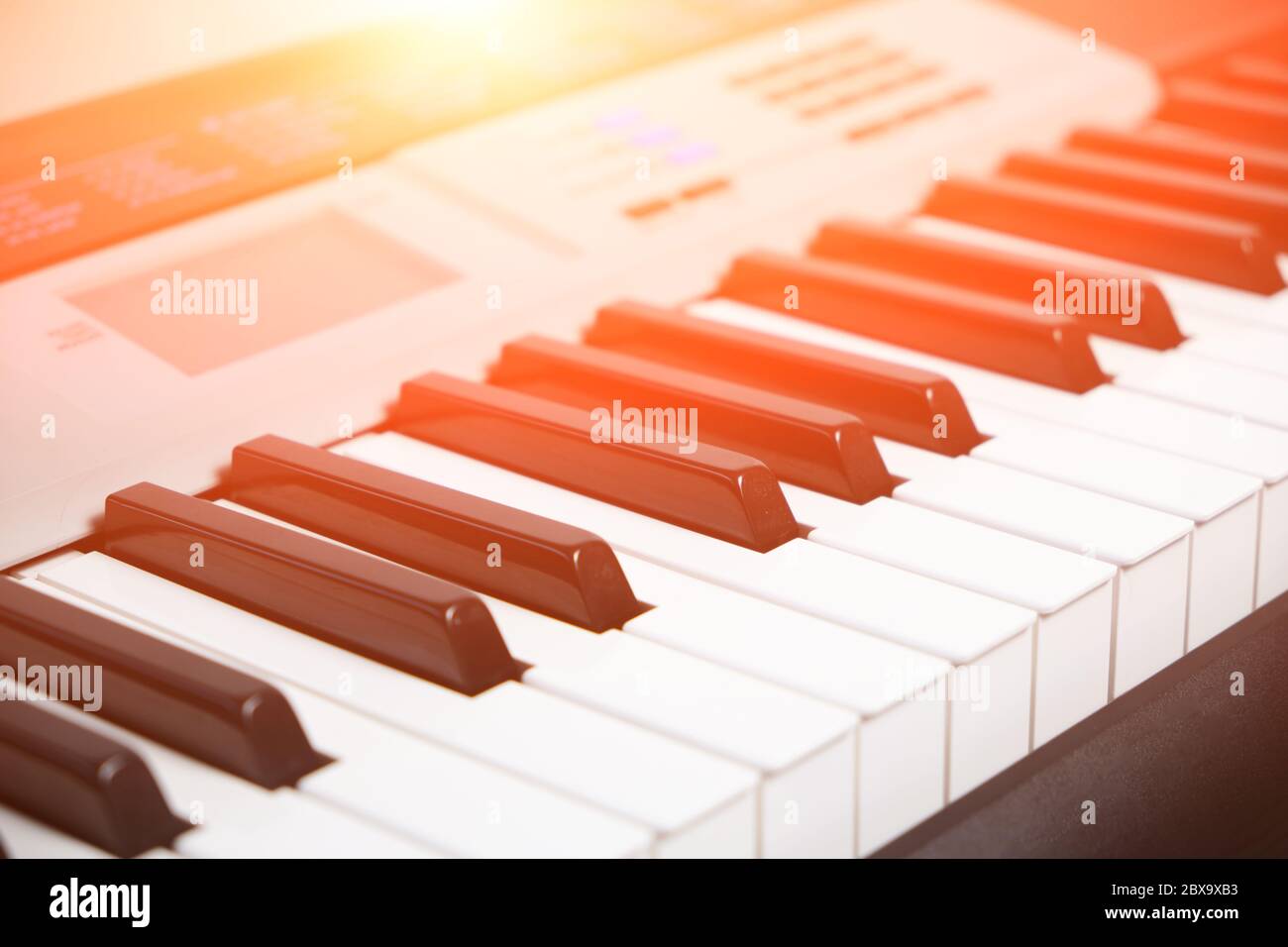 Tasti e pannello di controllo di un sintetizzatore musicale con luce solare intensa Foto Stock