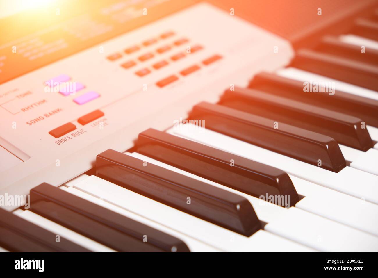 Tasti e pannello di controllo di un sintetizzatore musicale con luce solare intensa Foto Stock