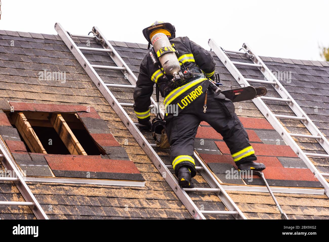 Vigili del fuoco in piedi sul tetto sostenuto da un attrezzo Halligan  durante l'addestramento al centro di addestramento del reparto di vigili  del fuoco di Worcester Foto stock - Alamy