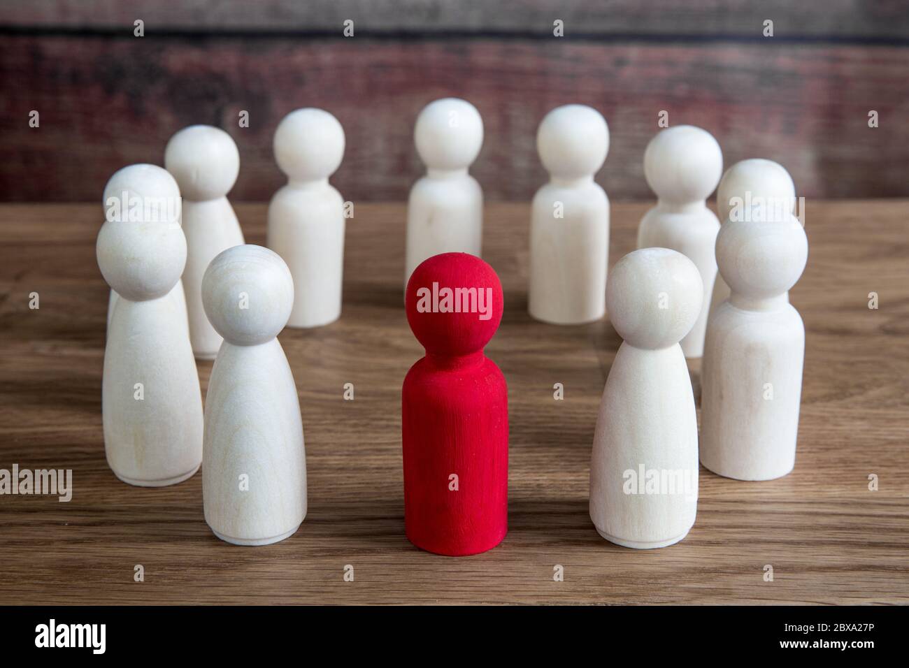 Un concetto aziendale o sociale di figure generiche raggruppate in un cerchio durante una riunione, una conferenza o un forum con un leader, un manager o un capo Foto Stock