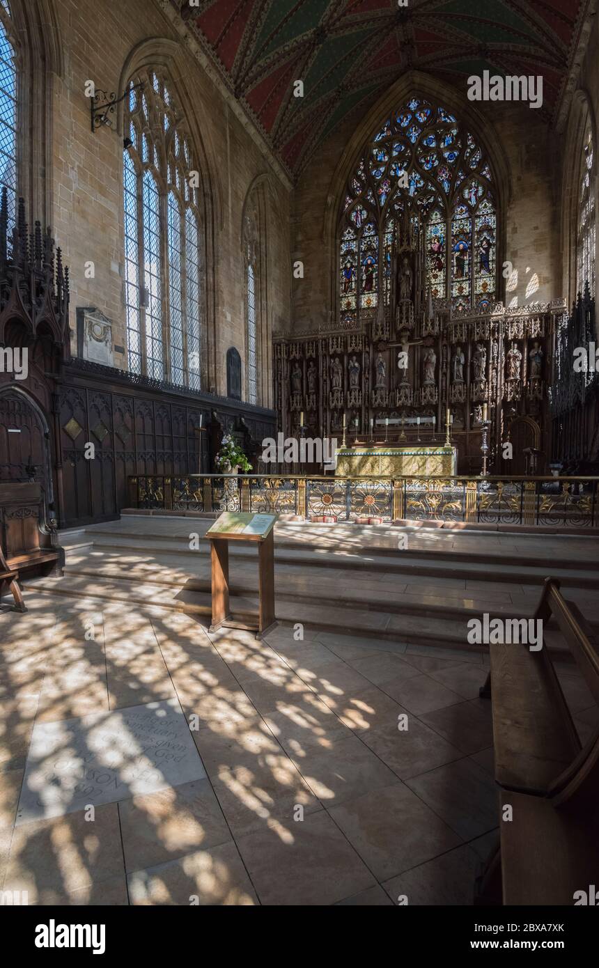 Interno di alto alter nella chiesa di St. Botolph a Boston, Lincolnshire con luce solare che scorre attraverso le finestre che gettano ombre modellate sul pavimento. Foto Stock