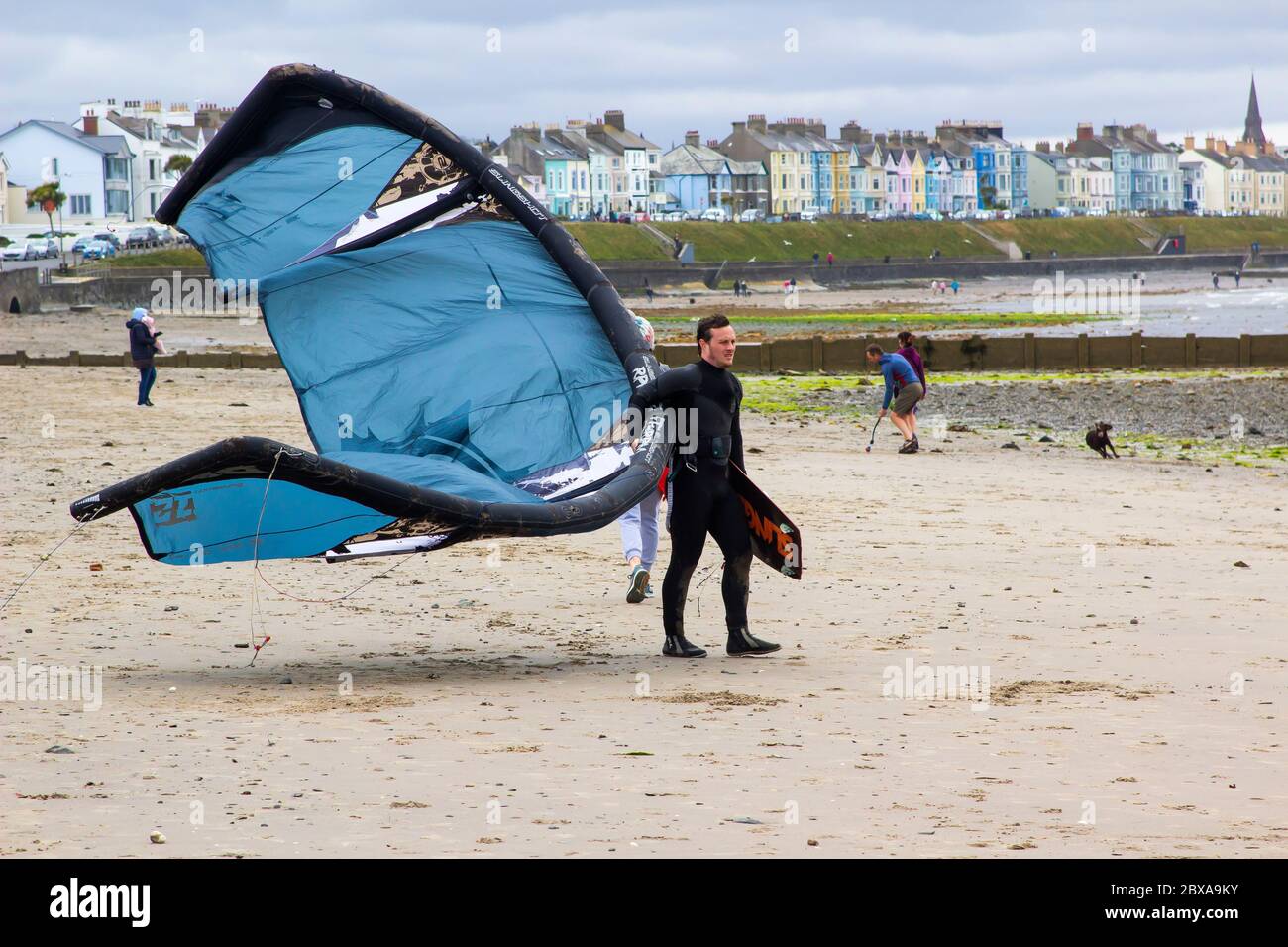 6 giugno 2020 UN giovane kite surfer maschile porta la sua attrezzatura al bordo dell'acqua a Ballyholme Beach a Bangor, Nortgern Irlanda mentre si prepara per alcuni a. Foto Stock
