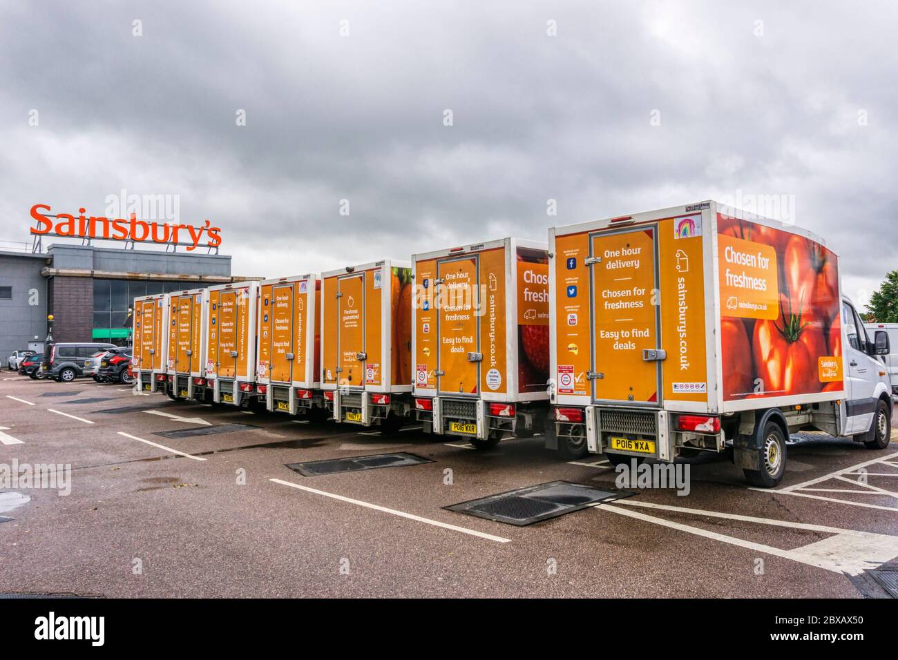 I furgoni di consegna di Sainsbury si sono allineati fuori dal supermercato a King's Lynn, Norfolk. Foto Stock