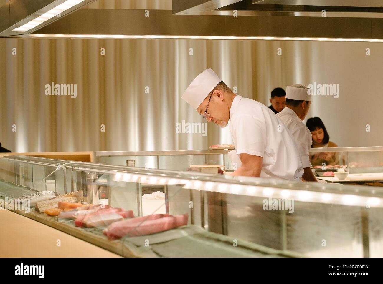 Chef sushi che lavora dietro il sushi bar Foto Stock