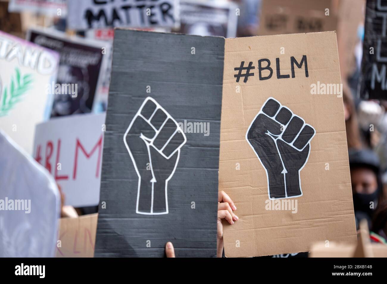 Due cartelli neri in casa del pugno BLM si distinguono in un mare di segni alla protesta di Black Lives Matter UK, Parliament Square, Londra, Inghilterra, Regno Unito Foto Stock