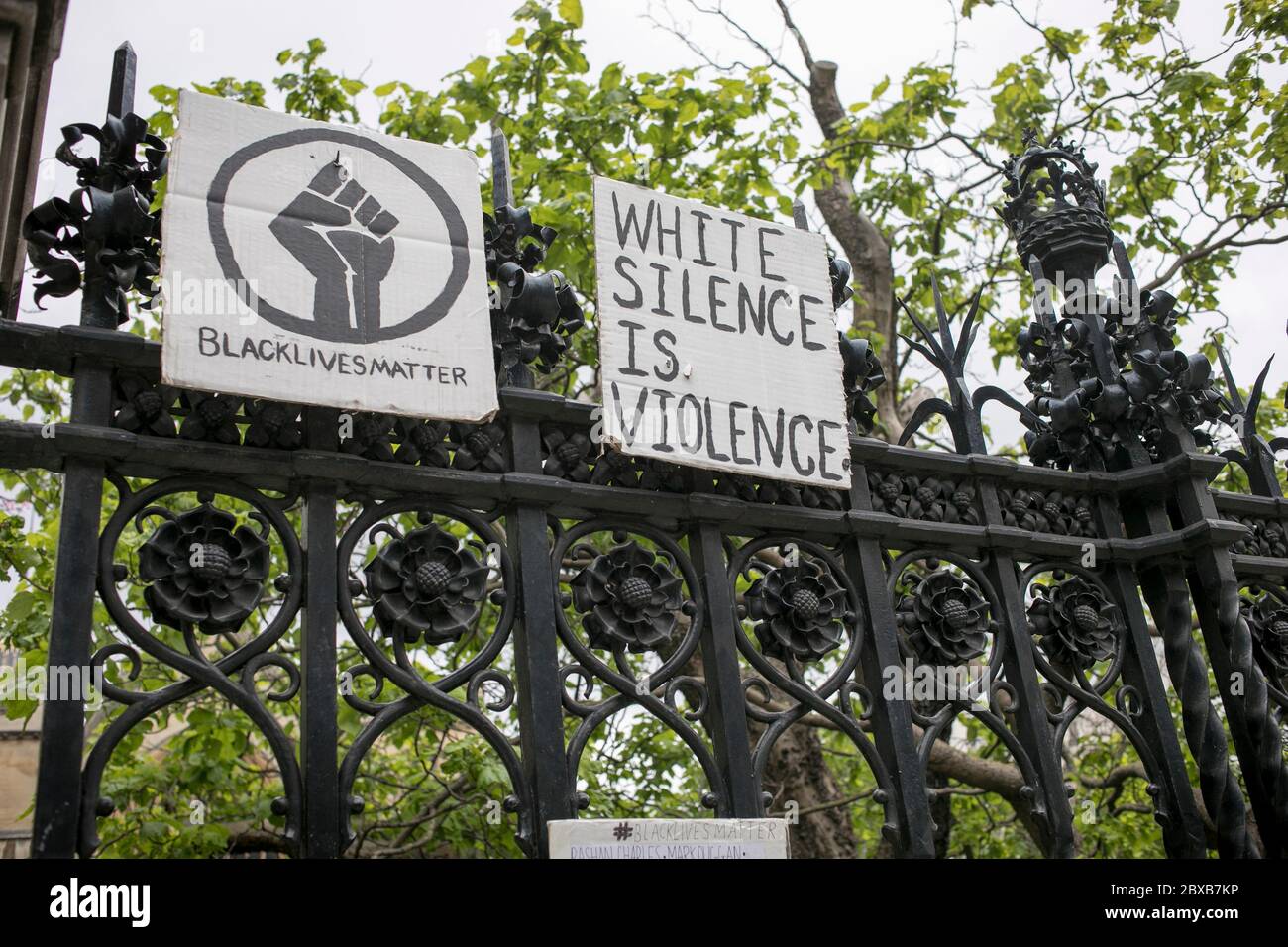 I cartelli sono esposti sulle ferrovie del Parlamento durante la protesta contro il razzismo a Londra, Regno Unito. Foto Stock