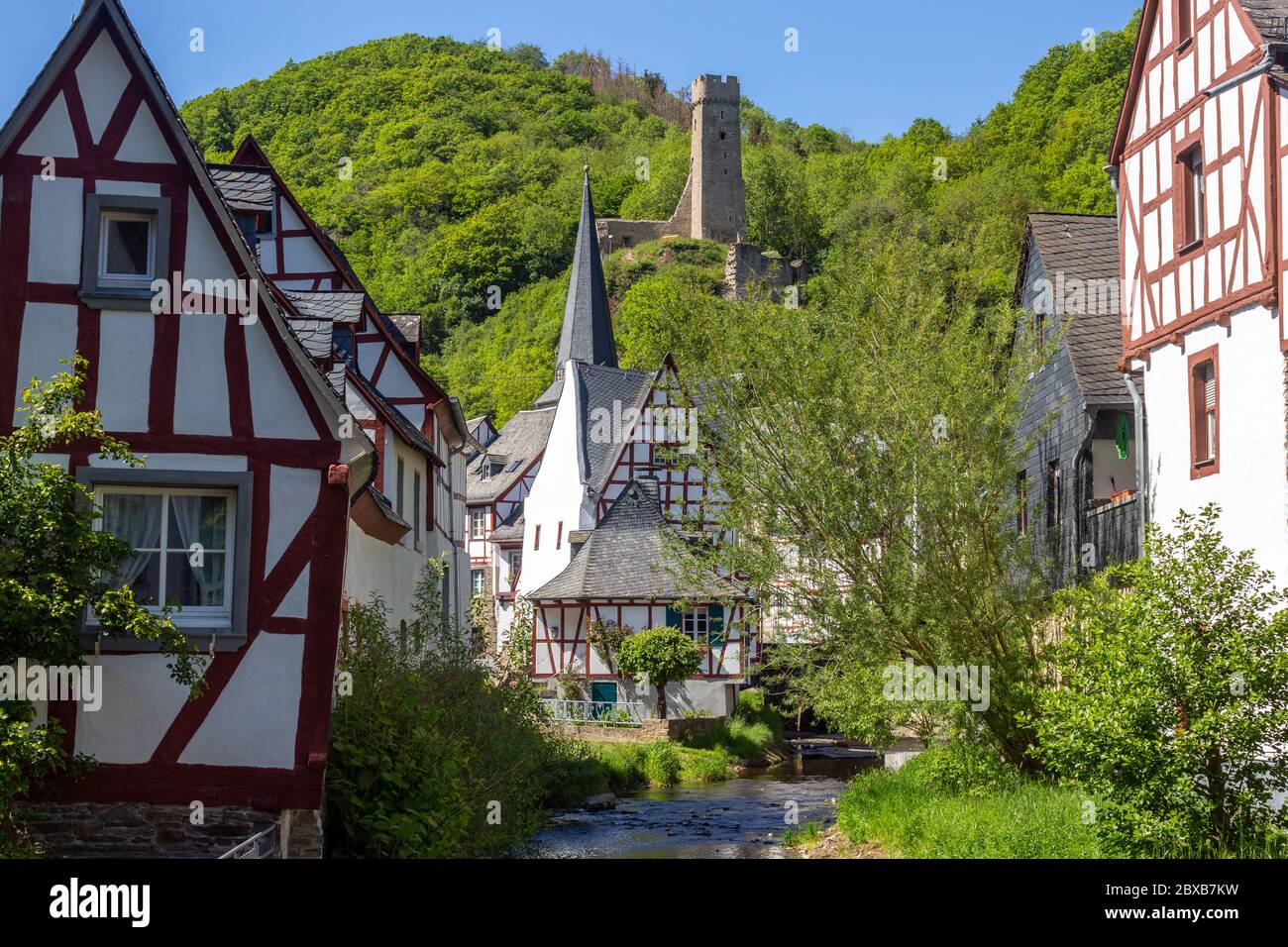 Il villaggio Monreal con il fiume elz, case a graticcio e il castello Loewenburg sullo sfondo Foto Stock