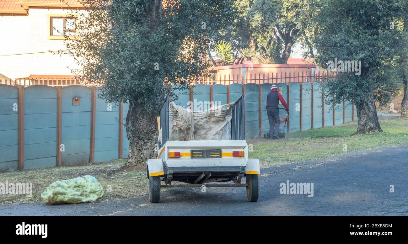 Alberton, Sudafrica - operatore di servizi di giardinaggio non identificato che si affida al suo commercio in un'immagine residenziale di sobborgo in formato orizzontale Foto Stock