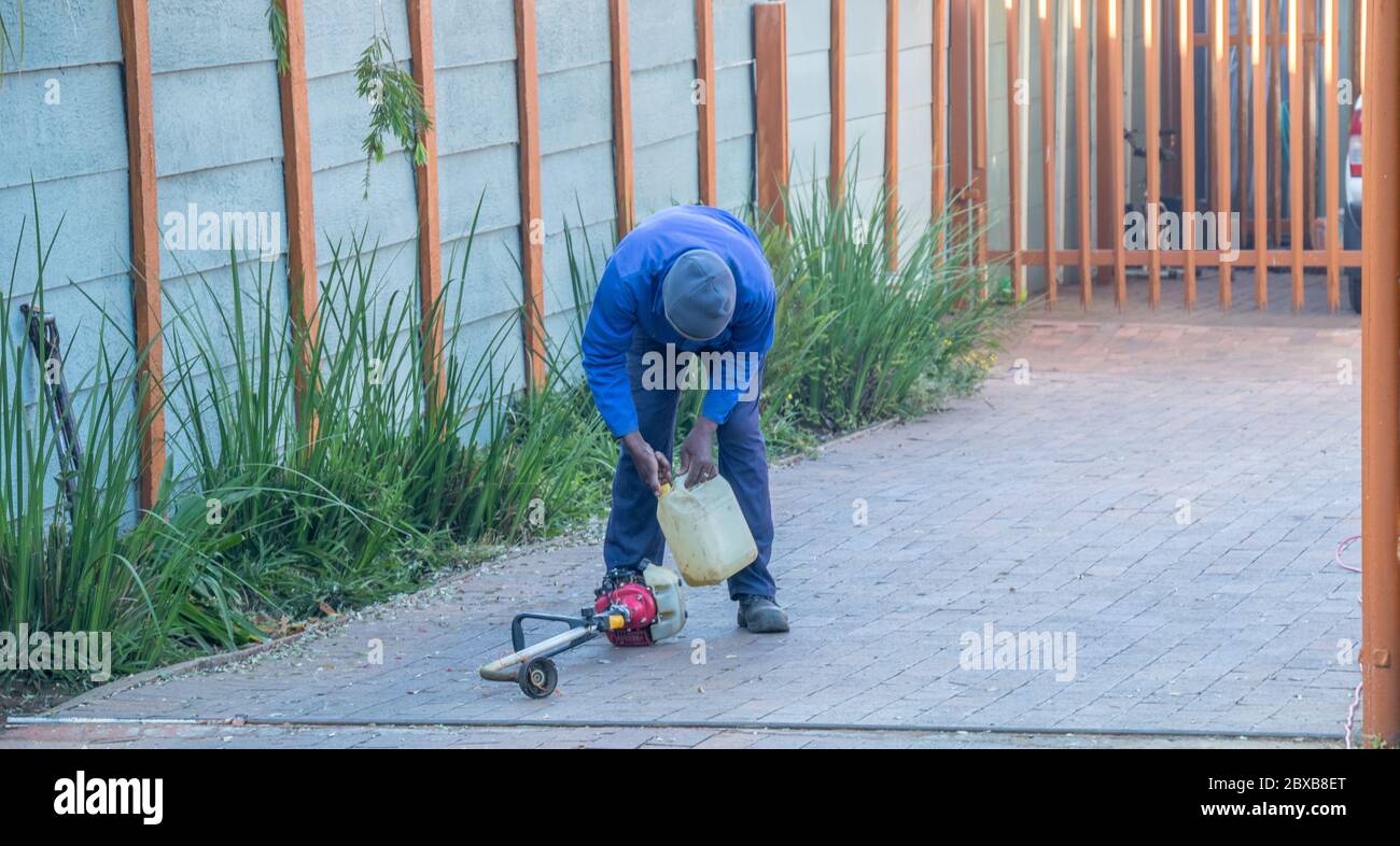 Alberton, Sudafrica - operatore di servizi di giardinaggio non identificato che si affida al suo commercio in un'immagine residenziale di sobborgo in formato orizzontale Foto Stock