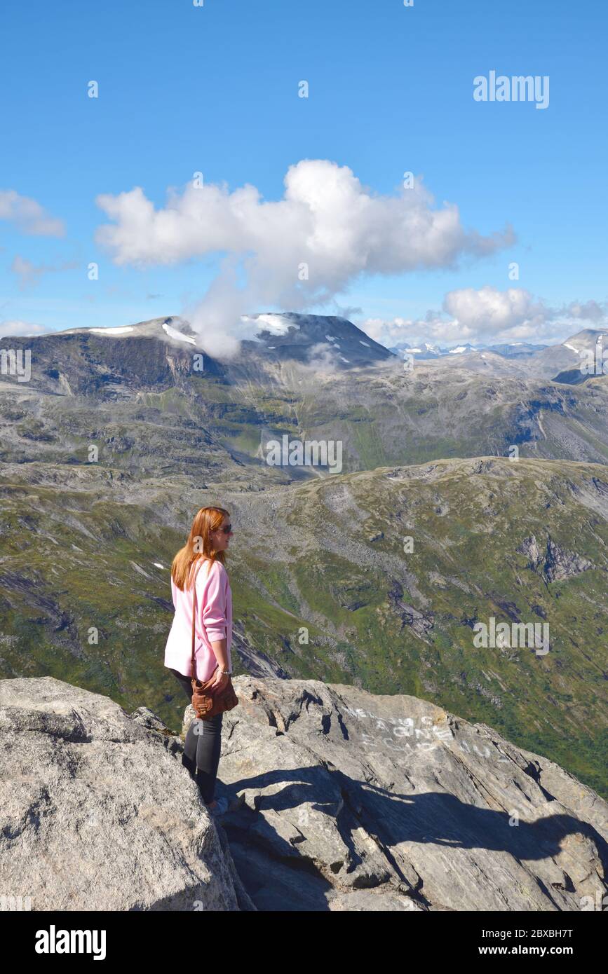 La giovane donna ammira il paesaggio da Dalsnibba, una montagna a 1500 m sul livello del mare e si affaccia sul Geirangerfjord, Norvegia. Foto Stock