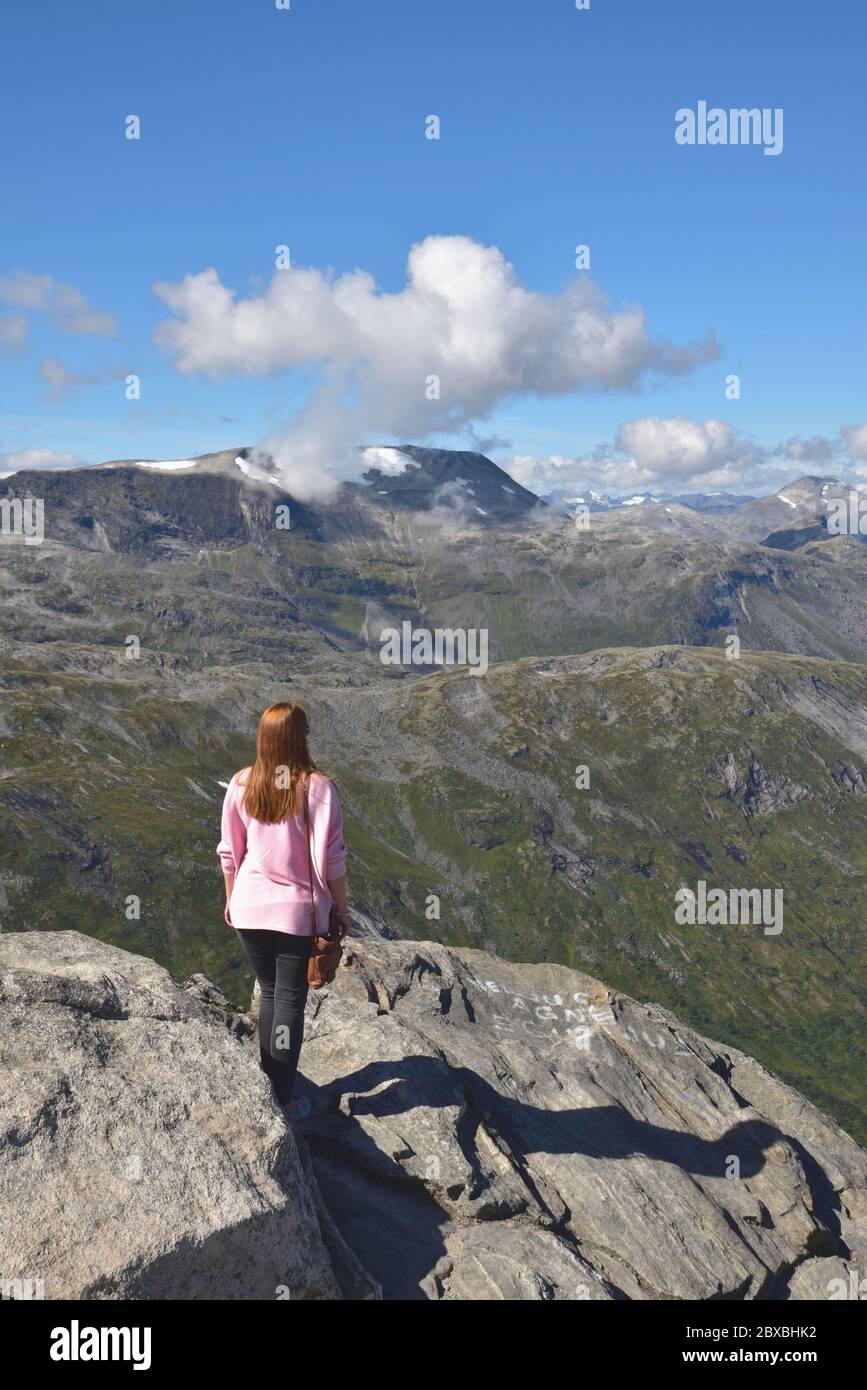 La giovane donna ammira il paesaggio da Dalsnibba, una montagna a 1500 m sul livello del mare e si affaccia sul Geirangerfjord, Norvegia. Foto Stock