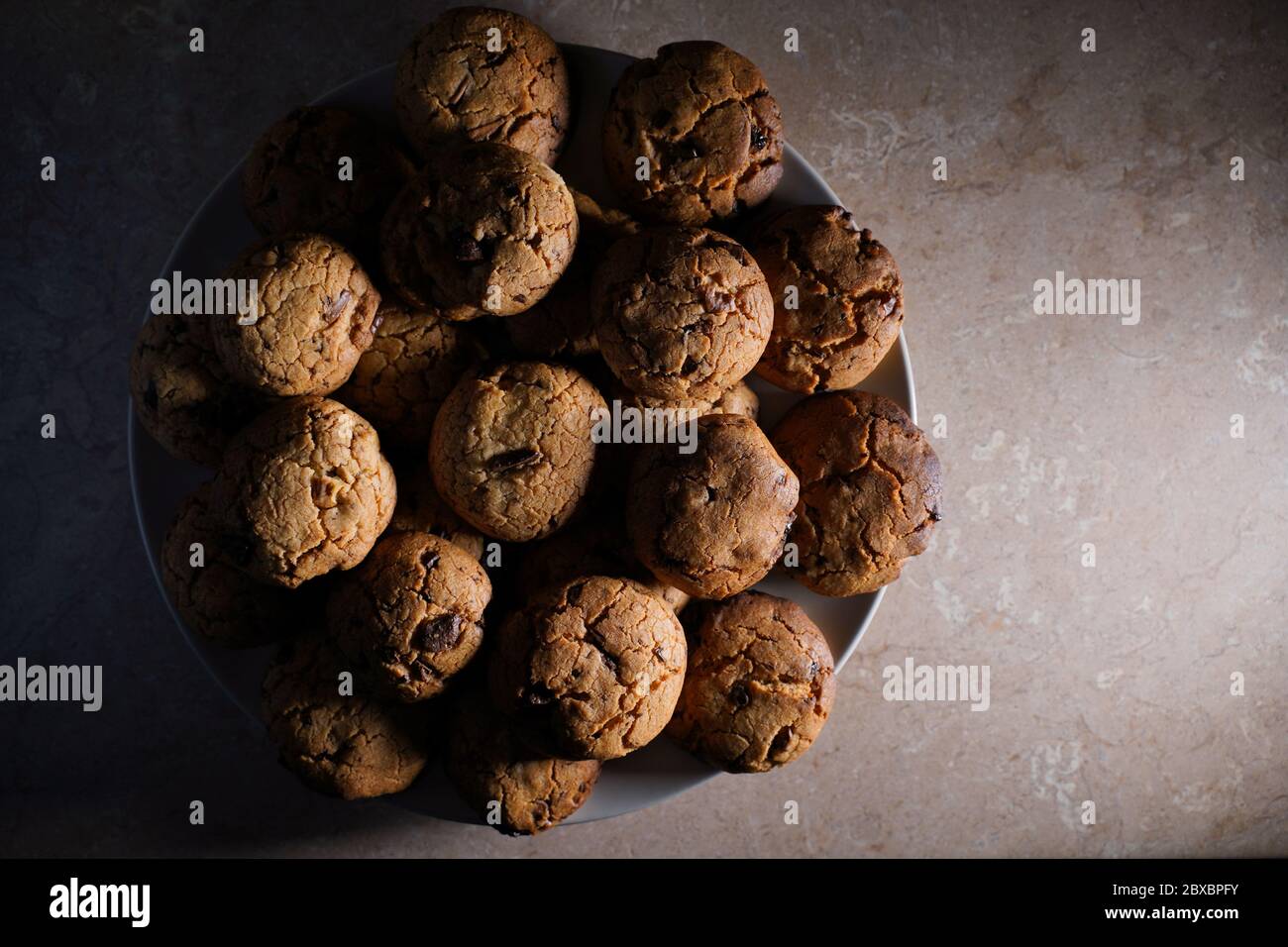 Biscotti su un piatto con luce scarsa. Vista dall'alto dello spazio di copia. Foto Stock