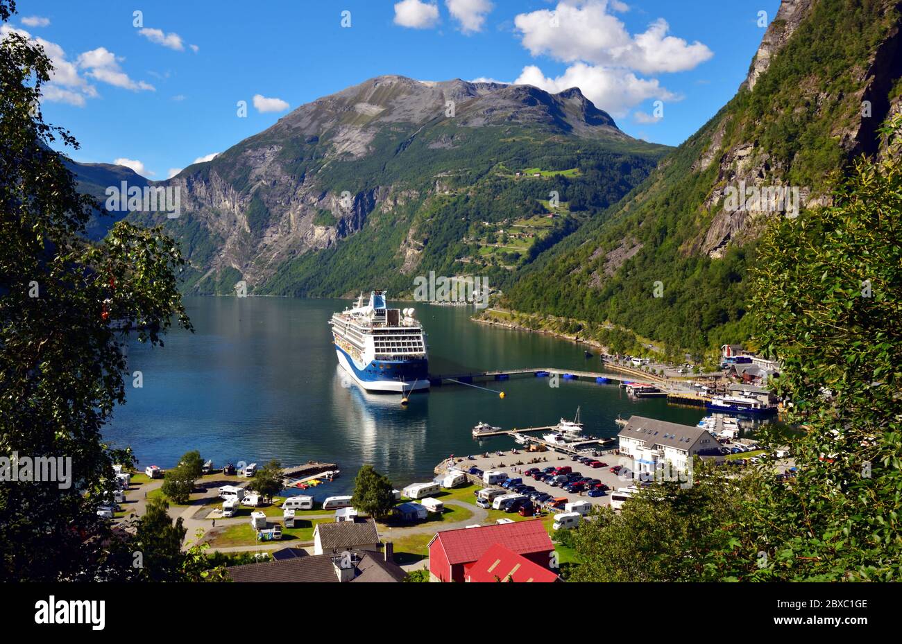 Il terminal delle navi da crociera a Geiranger, Norvegia, con la nave da crociera TUI Marella Discovery ormeggiava accanto. Foto Stock