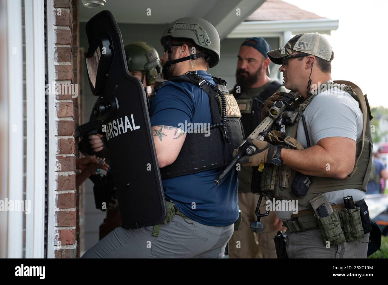 I marshals degli Stati Uniti e la polizia locale si preparano a violare una porta in cerca di un fuggitivo voluto per i reati violenti durante i 90 giorni, operazione multistato Triple Beam 26 luglio 2019 a St Louis, Missouri. L'operazione ha provocato più di 6,000 arresti in comunità colpite dalla violenza. Foto Stock