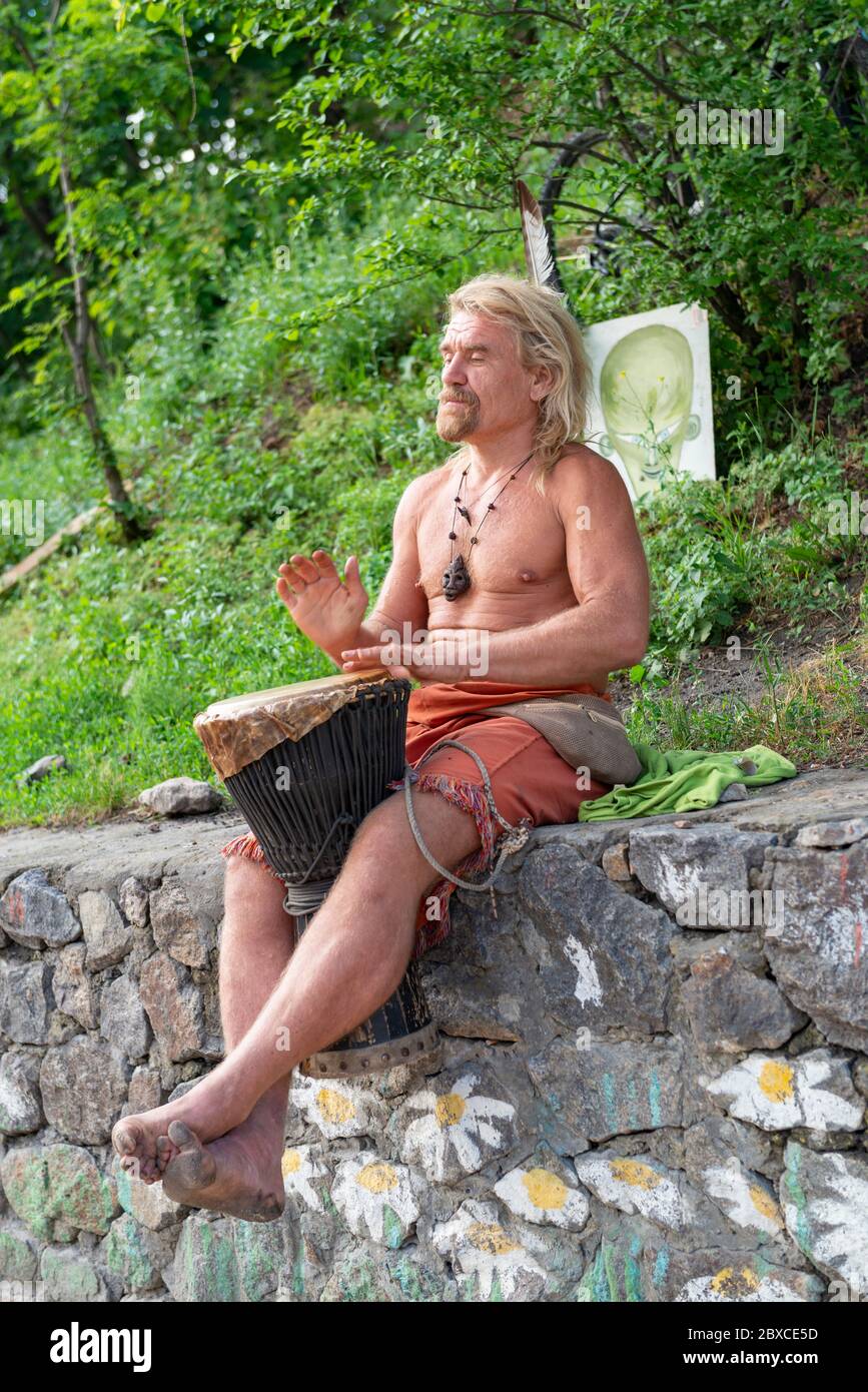 2018-05-19, Kiev, Ucraina. Il musicista di strada che assomiglia a Richard Brenson suona sul tamburo della mano. Hippie in festa di primavera tradizionale Foto Stock