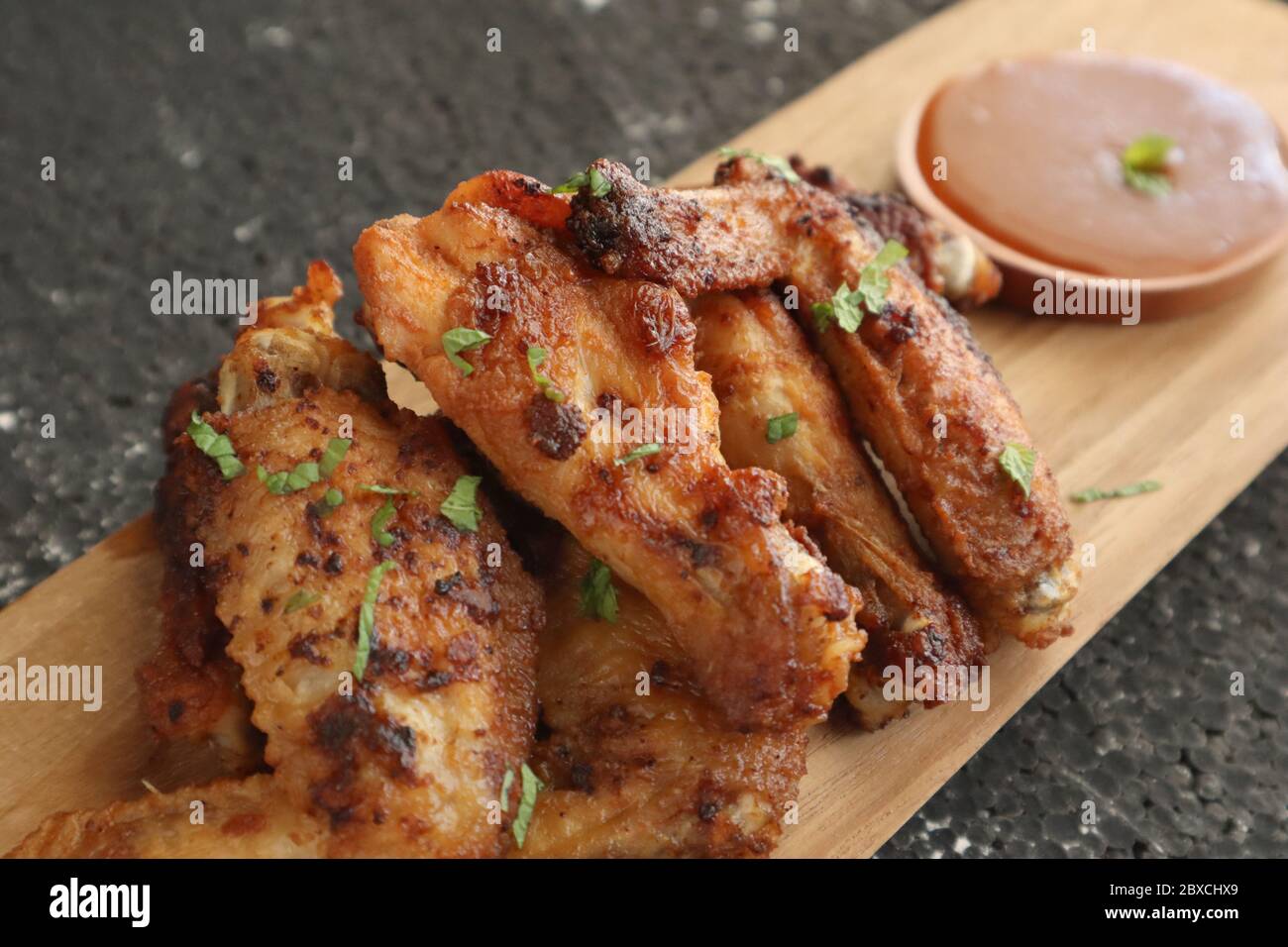 Deliziose ali di pollo, ali di pollo al forno o fritte servite con salsa piccante alla griglia, immagine ravvicinata Foto Stock