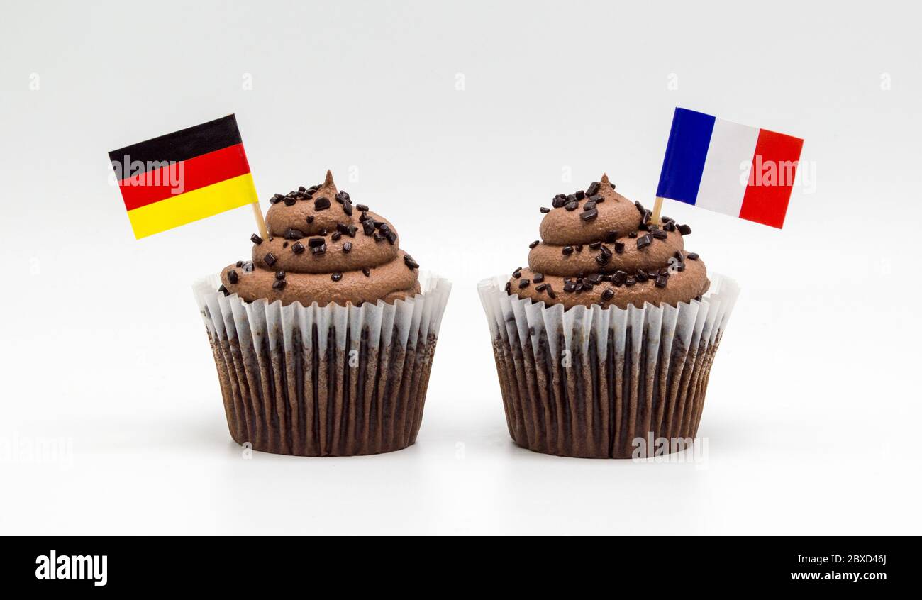 Due cupcake di cioccolato con bandiere tedesche e francesi isolate su bianco Foto Stock