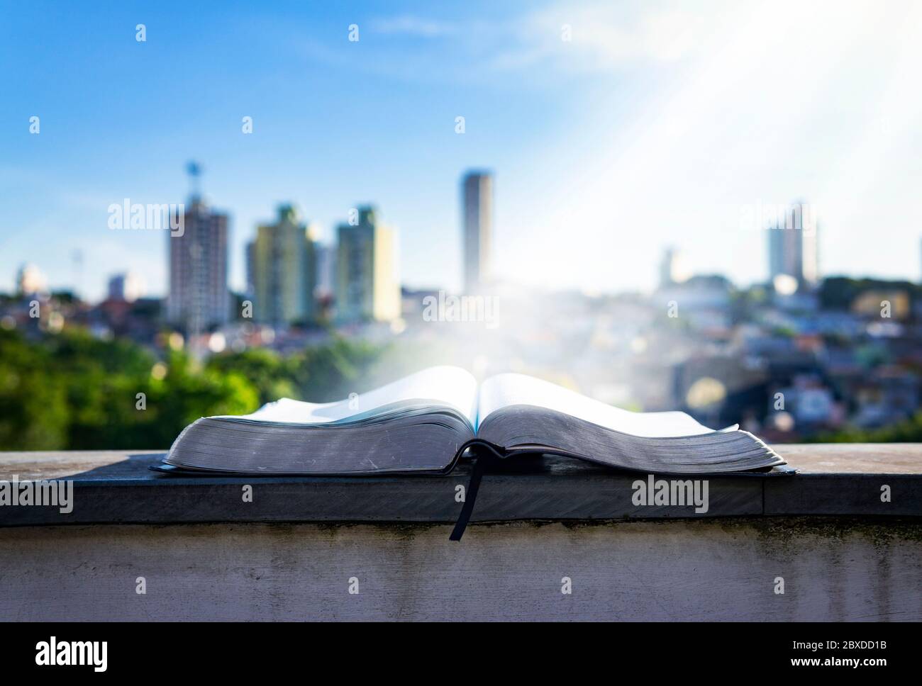 Luce sulla Bibbia nel concetto Urbano moderno cristiano della città Foto Stock