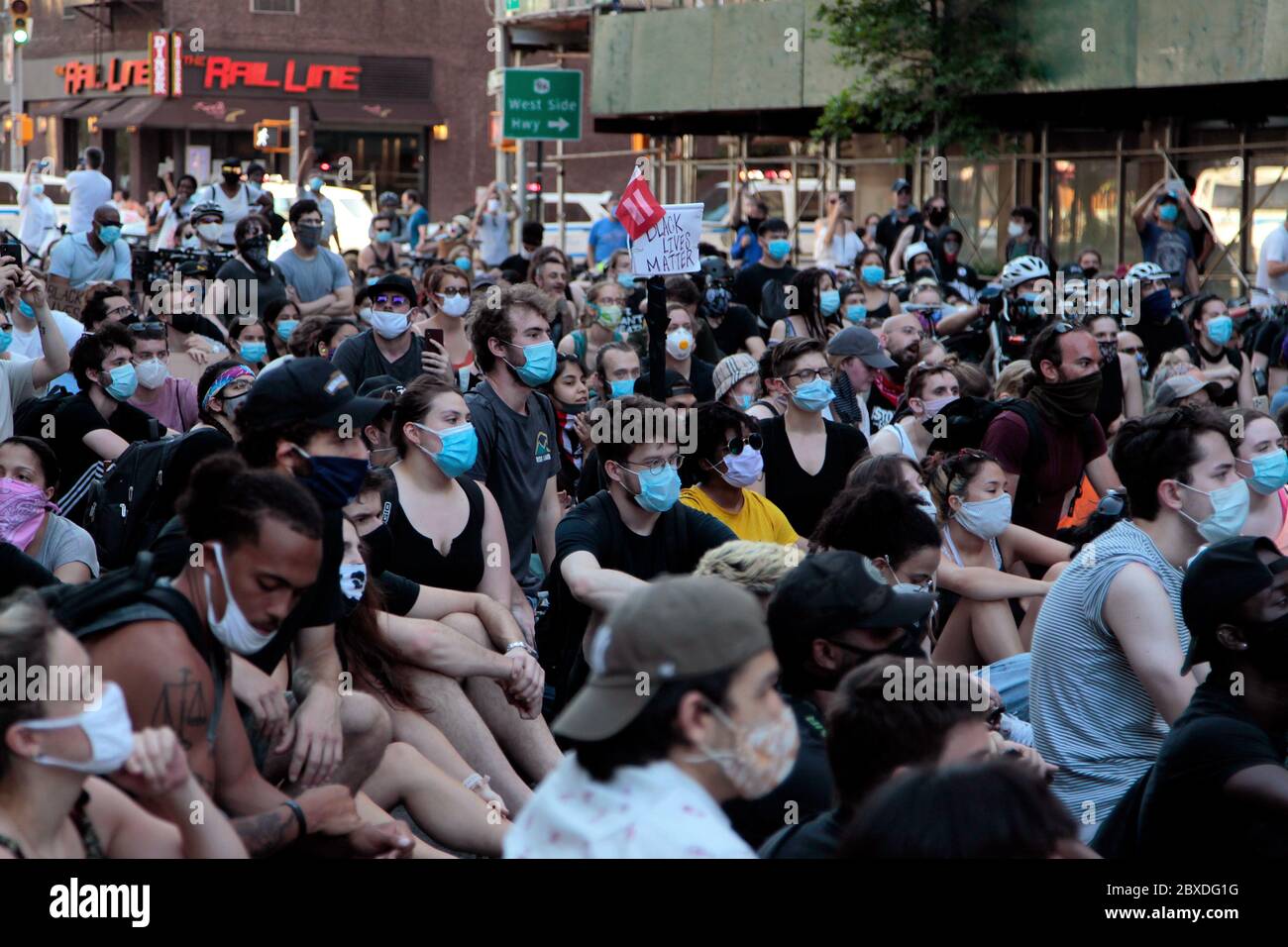 New York City, New York, Stati Uniti. 6 Giugno 2020. I manifestanti che marciano in risposta alla morte di George Floyd afroamericano, mentre si trovano nella custodia della polizia di Minneapolis, e a sostegno del movimento Black Lives Matter, si siedono sul marciapiede all'angolo tra 9th Avenue e West 23rd Street nel quartiere Chelsea di Manhattan oggi. È stata una delle centinaia di proteste negli Stati Uniti e nel mondo in risposta alla morte di Floyd la scorsa settimana. Credit: Adam Stoltman/Alamy Live News Foto Stock