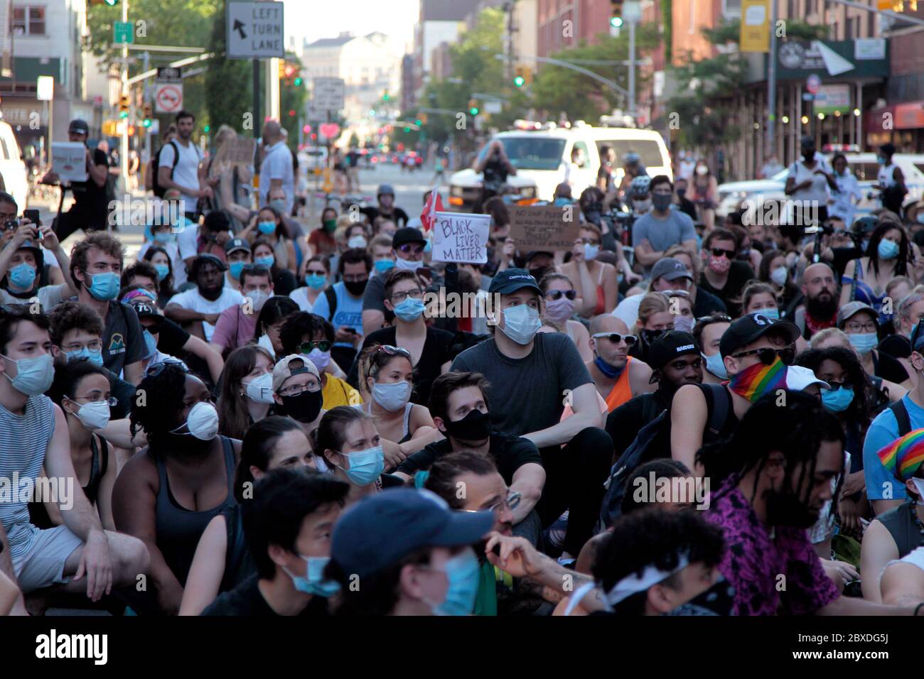 New York City, New York, Stati Uniti. 6 Giugno 2020. I manifestanti che marciano in risposta alla morte di George Floyd afroamericano, mentre si trovano nella custodia della polizia di Minneapolis, e a sostegno del movimento Black Lives Matter, si siedono sul marciapiede all'angolo tra 9th Avenue e West 23rd Street nel quartiere Chelsea di Manhattan oggi. È stata una delle centinaia di proteste negli Stati Uniti e nel mondo in risposta alla morte di Floyd la scorsa settimana. Credit: Adam Stoltman/Alamy Live News Foto Stock