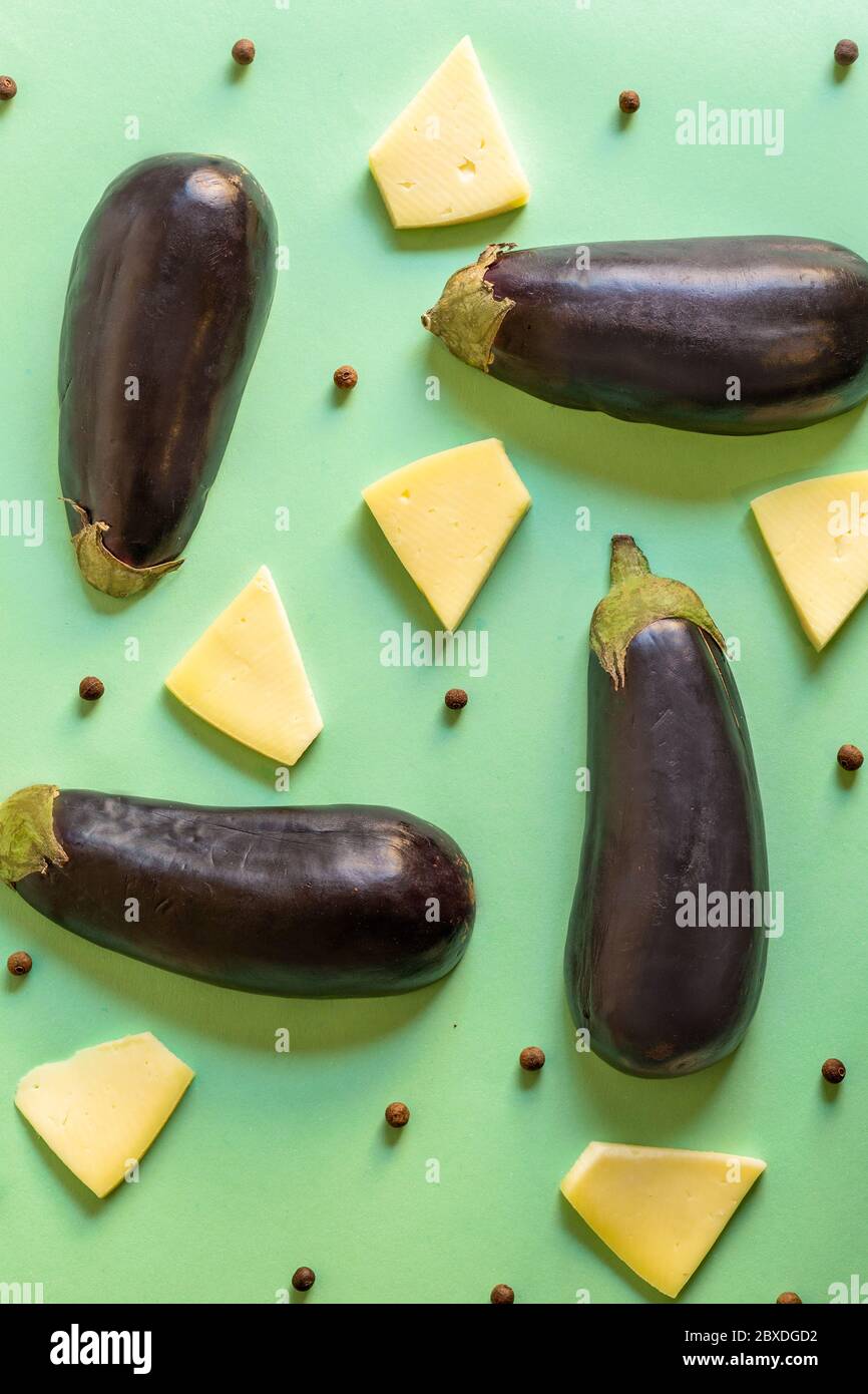melanzane con formaggio e peperoncini in un motivo su un sfondo verde e artistico Foto Stock