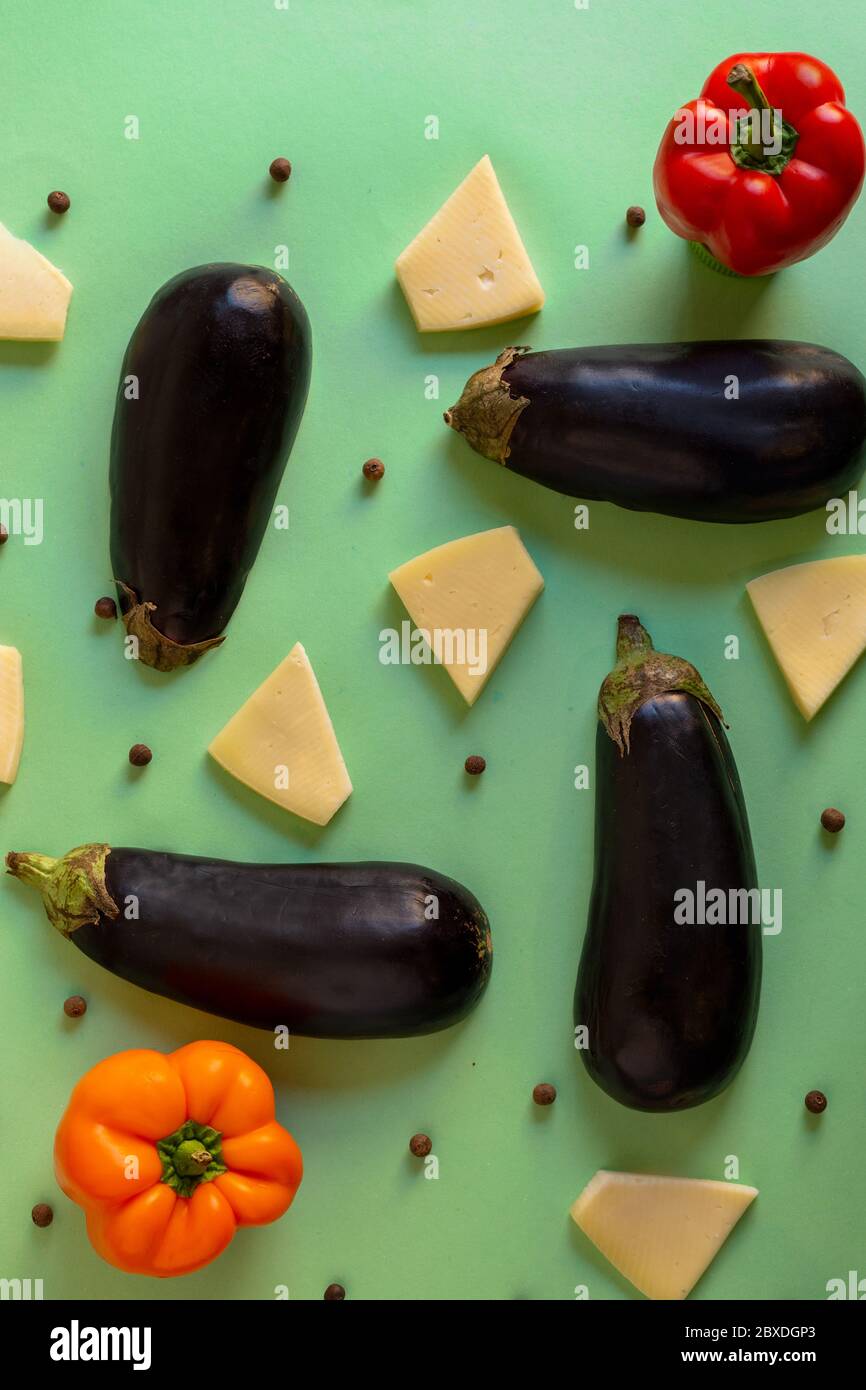 melanzane con formaggio e peperoncini in un motivo su sfondo bianco e artistico Foto Stock