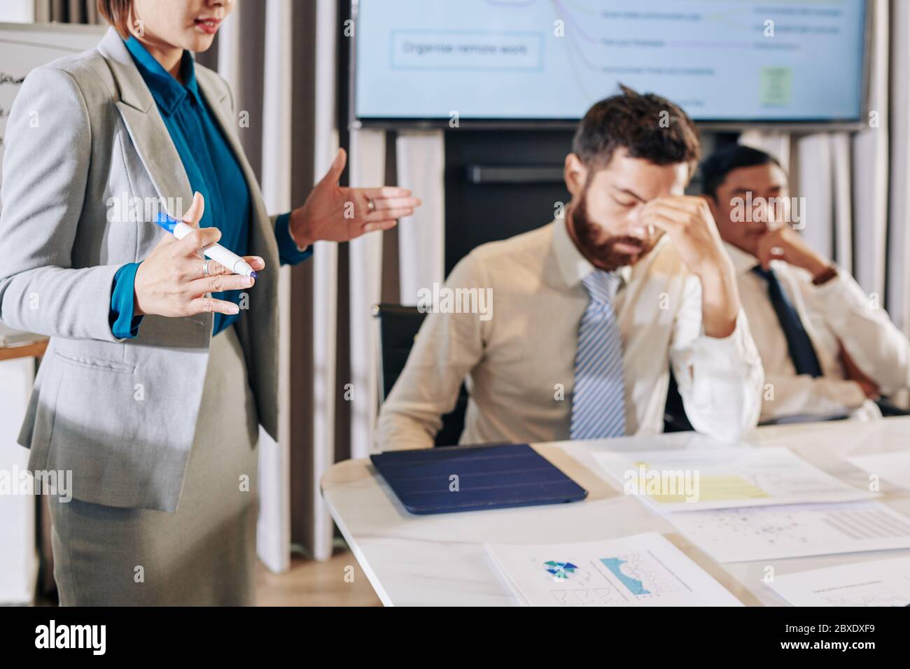 Imprenditrice femminile che informa il suo team sull'impatto economico della pandemia di covid-19 sull'azienda Foto Stock