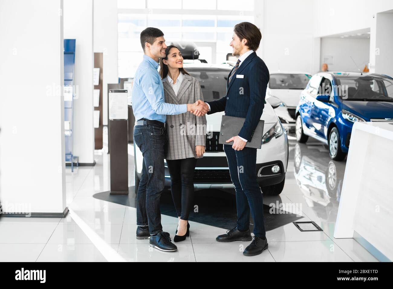 Manager Handshaking con i giovani acquirenti dopo aver avuto successo l'affare Foto Stock