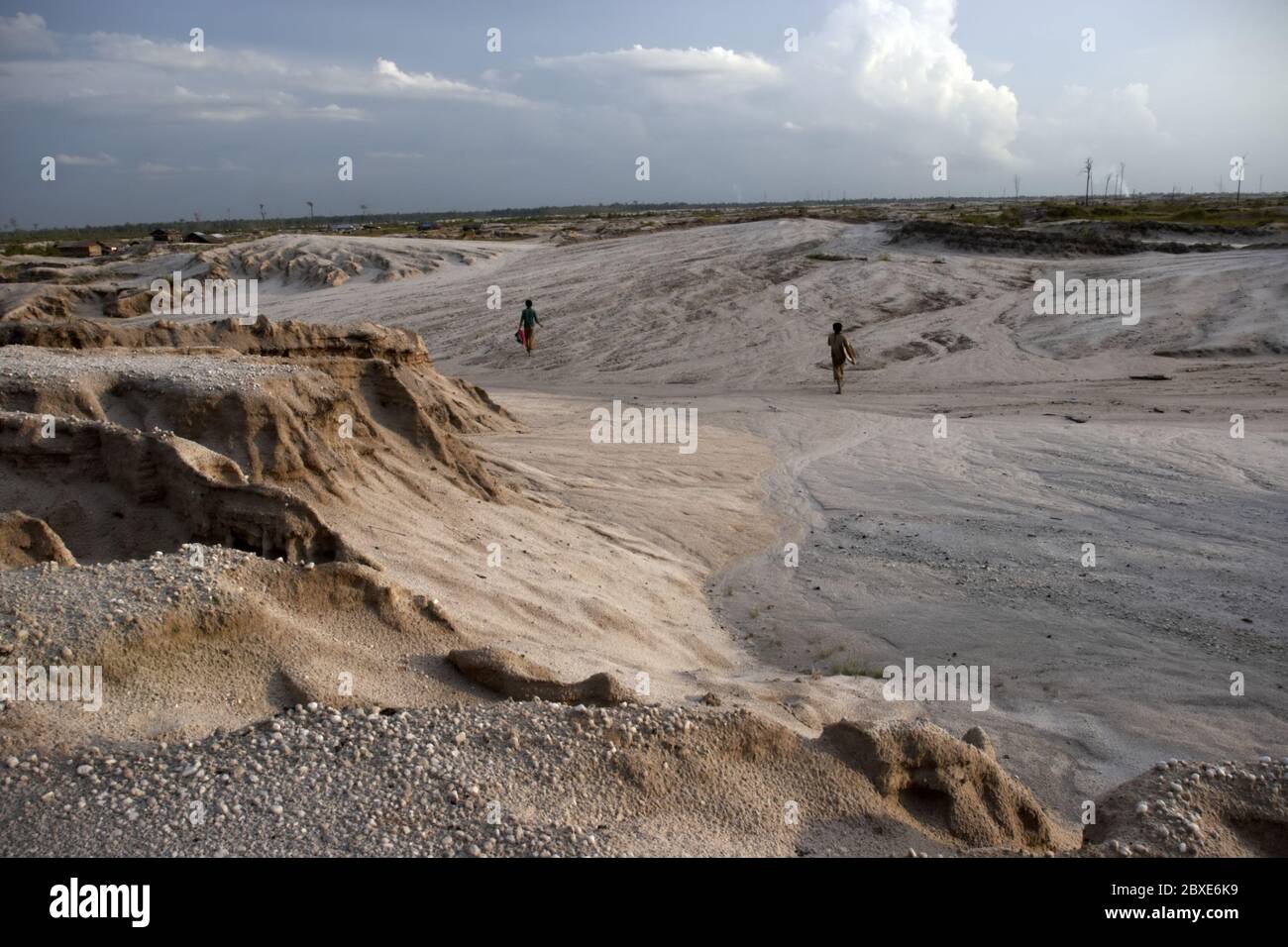 Minatori d'oro in scala ridotta che camminano sul paesaggio lunare nel sito di estrazione dell'oro di Galangan ad Hampalit, Kalimantan centrale, Indonesia. Foto Stock