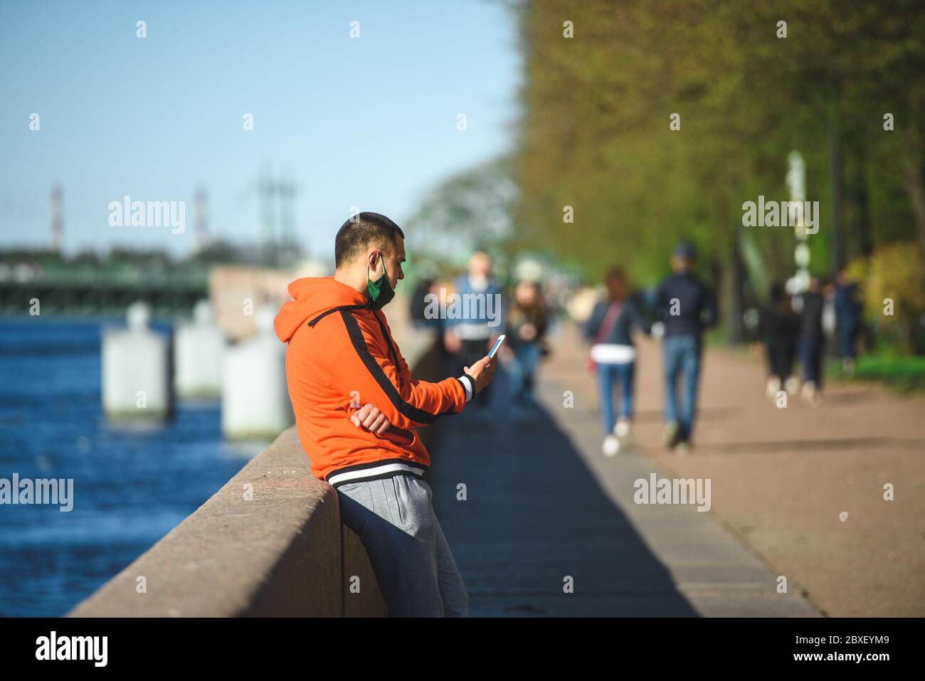 Russia, San Pietroburgo, 23 maggio 2020:un uomo con un telefono poggia sull'argine Foto Stock