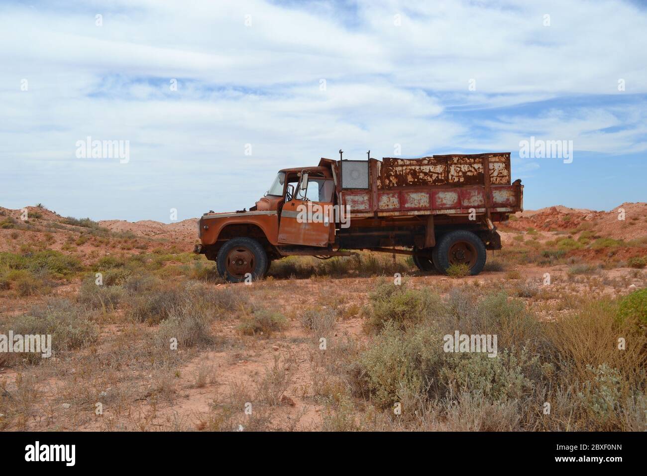 Vecchia punta di miniera arrugginita o camion di scarico abbandonato nel deserto vicino alla città di Coober Pedy in Australia Foto Stock